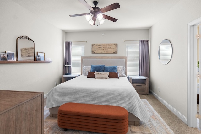 carpeted bedroom with baseboards, multiple windows, and a ceiling fan