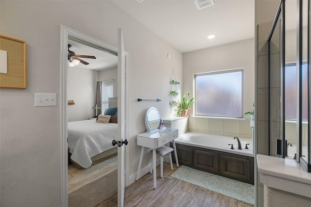 full bathroom featuring visible vents, wood finished floors, a garden tub, and ensuite bath