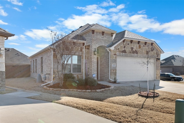 view of front of house with brick siding, stone siding, driveway, and an attached garage