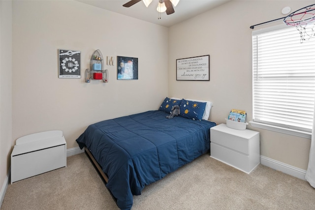 carpeted bedroom featuring a ceiling fan and baseboards