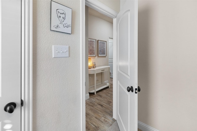 corridor featuring wood finished floors and baseboards