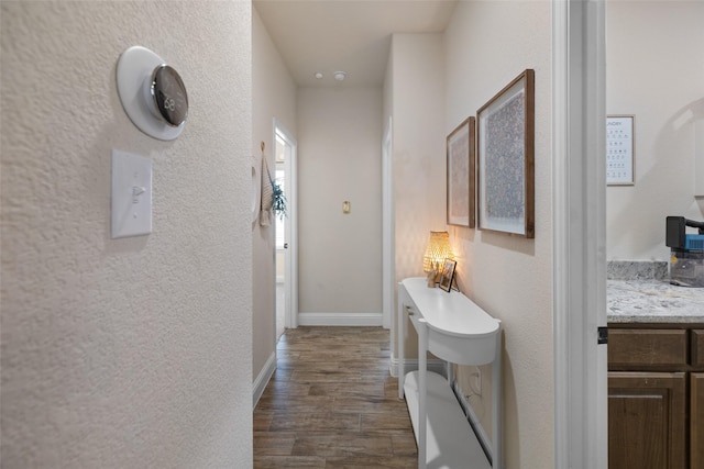 hall featuring dark wood finished floors and baseboards