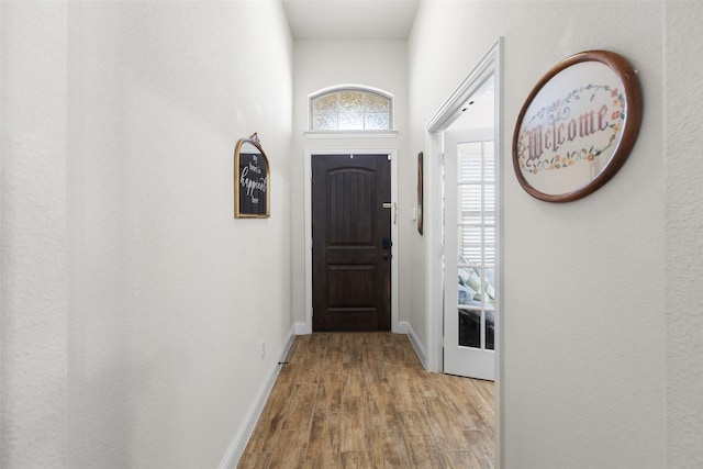 doorway to outside featuring wood finished floors and baseboards