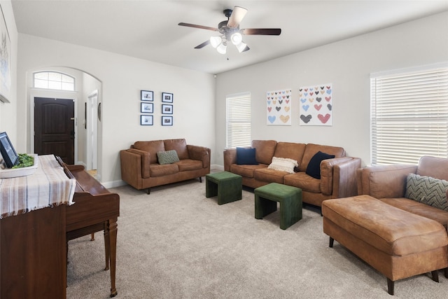 living area with a wealth of natural light, light carpet, and arched walkways