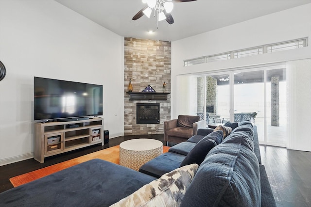 living room with ceiling fan, a fireplace, baseboards, and wood finished floors