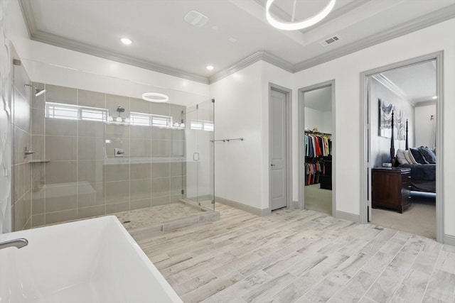 bathroom featuring visible vents, baseboards, a soaking tub, a shower stall, and crown molding