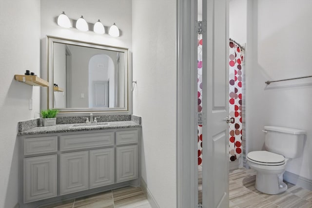 bathroom with a shower with curtain, baseboards, toilet, and vanity