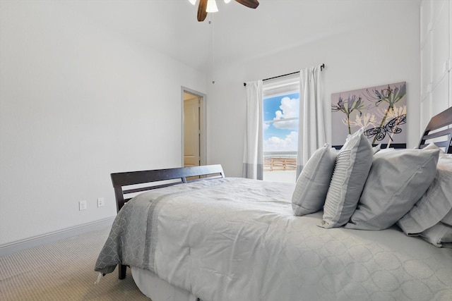 carpeted bedroom featuring a high ceiling, a ceiling fan, and baseboards