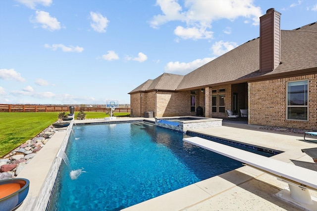 view of swimming pool featuring a patio, fence, a diving board, a pool with connected hot tub, and a lawn