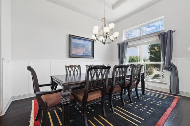 dining space with a wainscoted wall, hardwood / wood-style flooring, crown molding, a decorative wall, and a notable chandelier