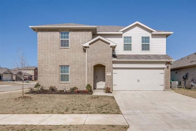 traditional-style home with an attached garage, central AC unit, brick siding, and driveway