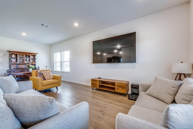 living room featuring recessed lighting, visible vents, baseboards, and wood finished floors