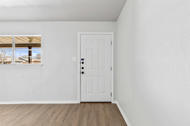 foyer entrance featuring wood finished floors and baseboards