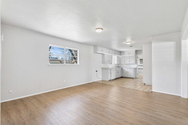 unfurnished living room with baseboards and light wood-style floors