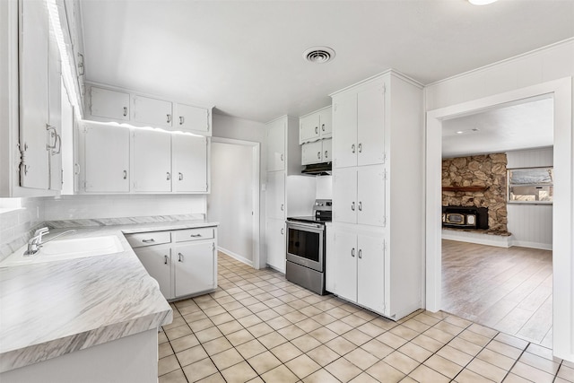 kitchen featuring visible vents, light countertops, electric stove, white cabinets, and a sink