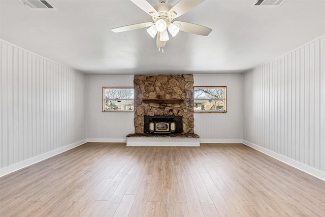 unfurnished living room with a wealth of natural light, visible vents, and wood finished floors