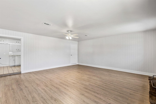 spare room featuring visible vents, baseboards, ceiling fan, and light wood finished floors