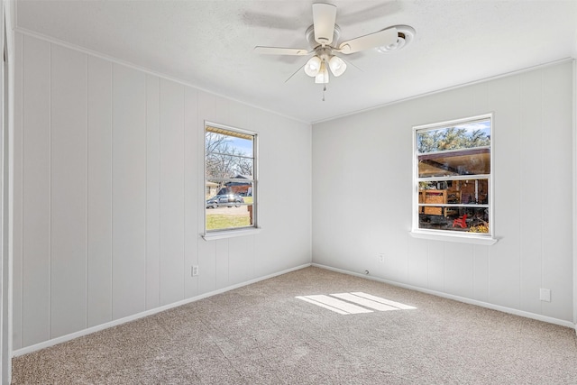 carpeted empty room featuring baseboards and ceiling fan