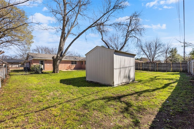 view of yard with an outdoor structure, a storage unit, and a fenced backyard