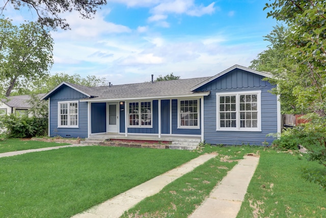 view of front of house featuring a porch, roof with shingles, board and batten siding, and a front lawn