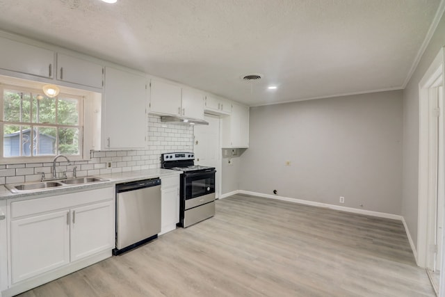 kitchen featuring visible vents, a sink, under cabinet range hood, tasteful backsplash, and stainless steel appliances