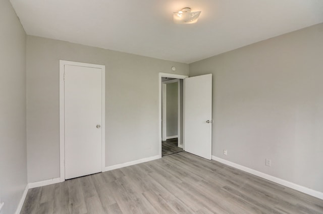 unfurnished bedroom with baseboards and wood finished floors