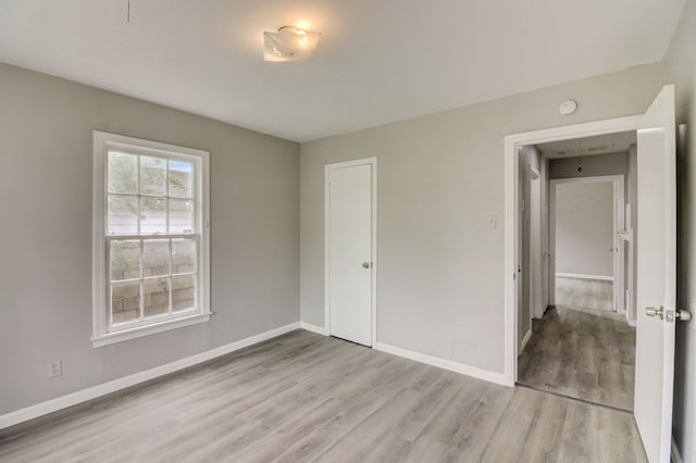 unfurnished bedroom with a closet, baseboards, and wood finished floors