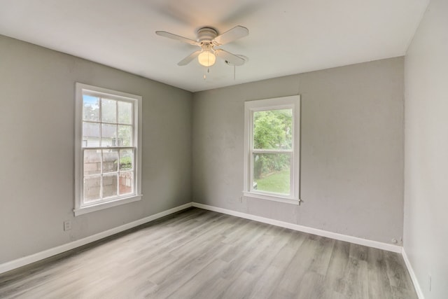 unfurnished room with wood finished floors, baseboards, and ceiling fan