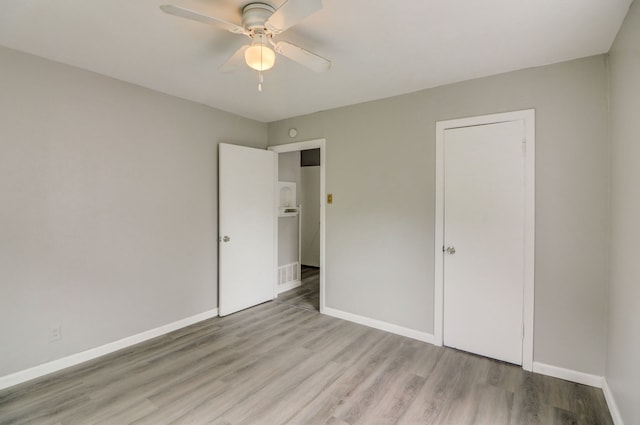 unfurnished bedroom with visible vents, wood finished floors, baseboards, and ceiling fan