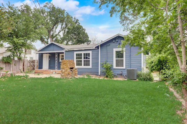 view of front of home featuring a front yard, cooling unit, fence, and a porch