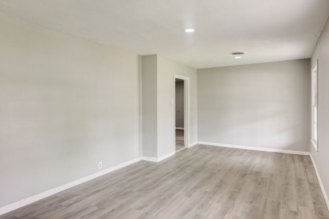 spare room featuring visible vents, baseboards, and wood finished floors