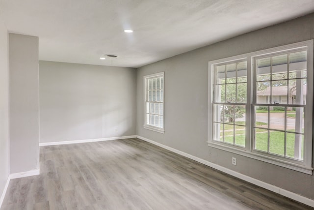 empty room with a healthy amount of sunlight and baseboards