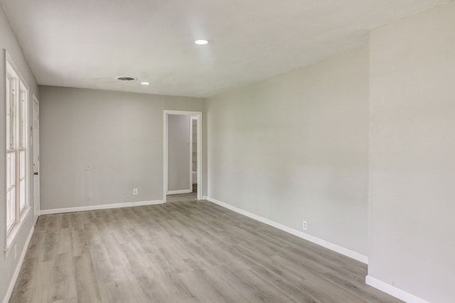 spare room featuring visible vents, recessed lighting, wood finished floors, and baseboards