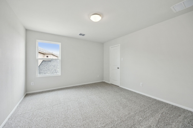 empty room featuring visible vents, baseboards, and carpet