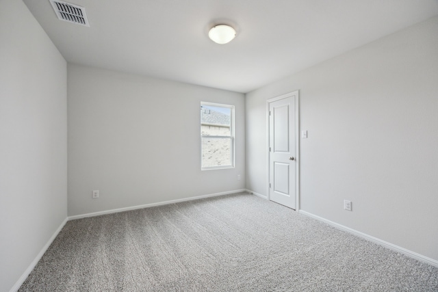 spare room featuring carpet flooring, visible vents, and baseboards