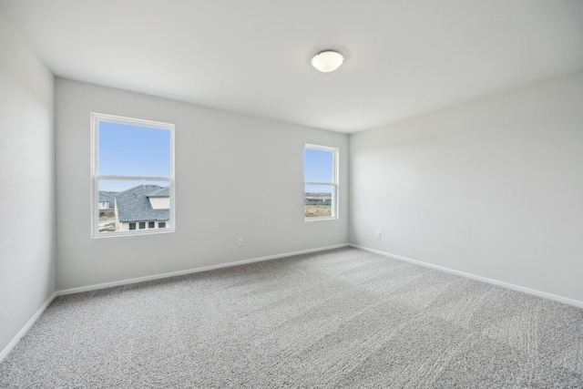 empty room with baseboards and carpet