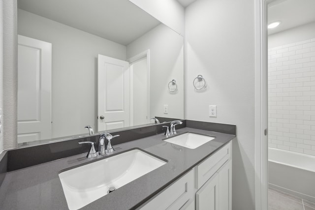 full bath featuring double vanity, shower / bathing tub combination, and a sink