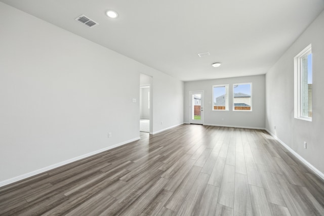 spare room featuring visible vents, baseboards, and dark wood finished floors