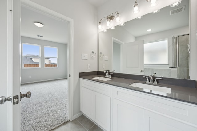 full bath with a sink, visible vents, and double vanity