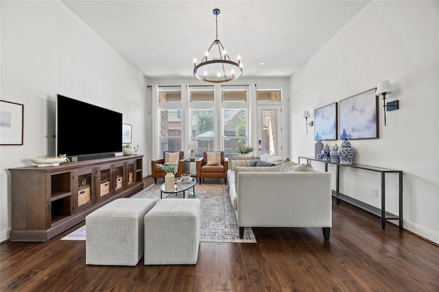 living area with an inviting chandelier, baseboards, and dark wood-style flooring