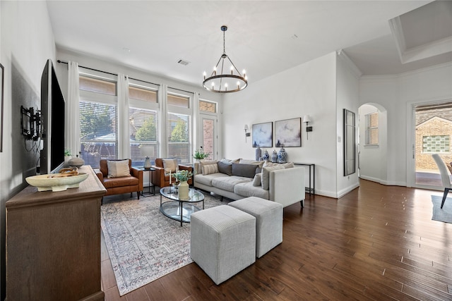 living area with visible vents, dark wood-type flooring, baseboards, arched walkways, and a notable chandelier