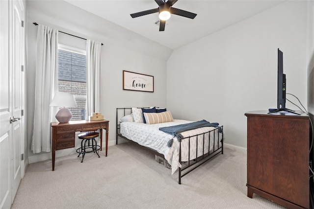 bedroom featuring light colored carpet, baseboards, lofted ceiling, and ceiling fan