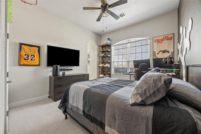 carpeted bedroom featuring visible vents, baseboards, arched walkways, and ceiling fan