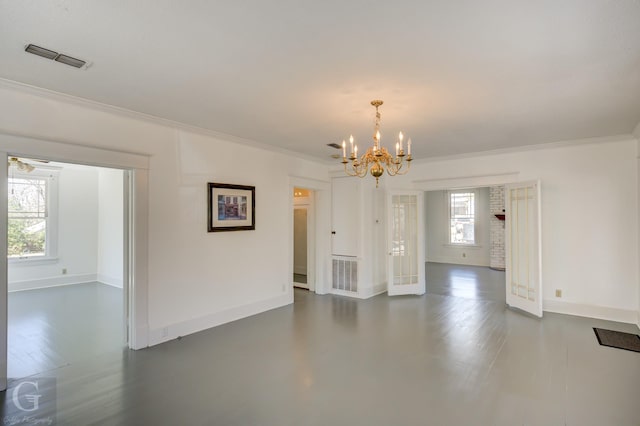 interior space with visible vents, baseboards, an inviting chandelier, and ornamental molding