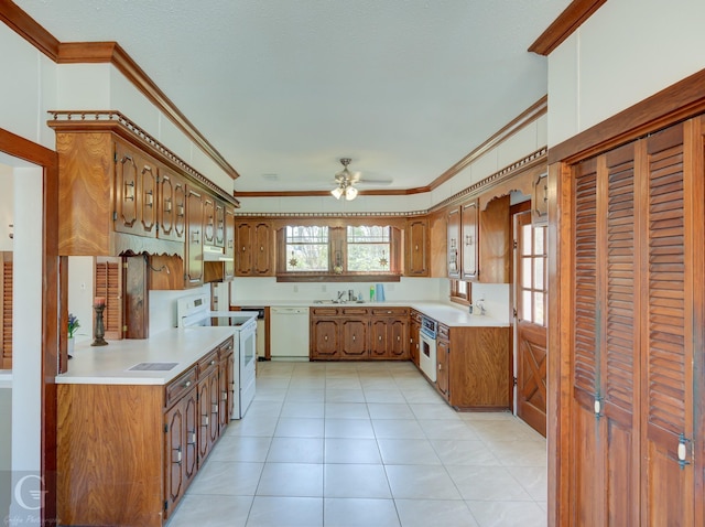 kitchen with a healthy amount of sunlight, white appliances, crown molding, and a sink