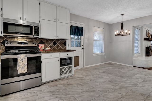 kitchen featuring stainless steel appliances, dark countertops, white cabinets, and decorative backsplash