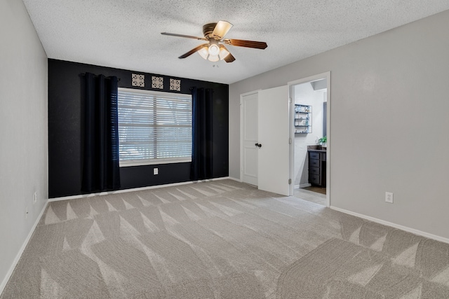 empty room featuring baseboards, light carpet, a textured ceiling, and ceiling fan