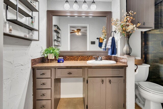 bathroom with toilet, a ceiling fan, backsplash, tile patterned flooring, and vanity