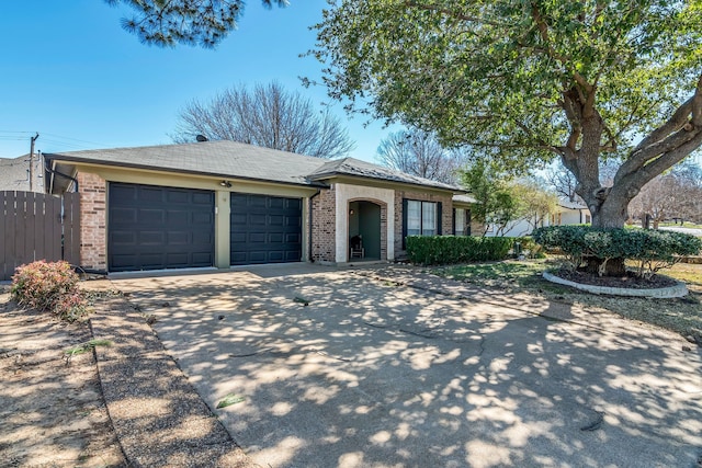 ranch-style home featuring concrete driveway, an attached garage, fence, and brick siding