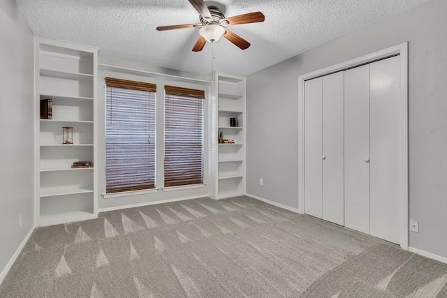 unfurnished bedroom featuring baseboards, ceiling fan, a closet, a textured ceiling, and carpet flooring